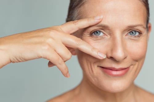 smiling senior woman with perfect skin showing victory sign near eye-img-blog