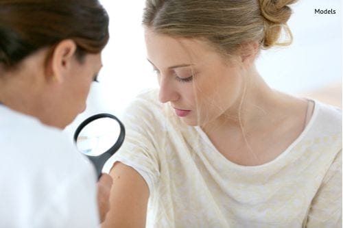 Young woman seeing doctor for dermatological control
