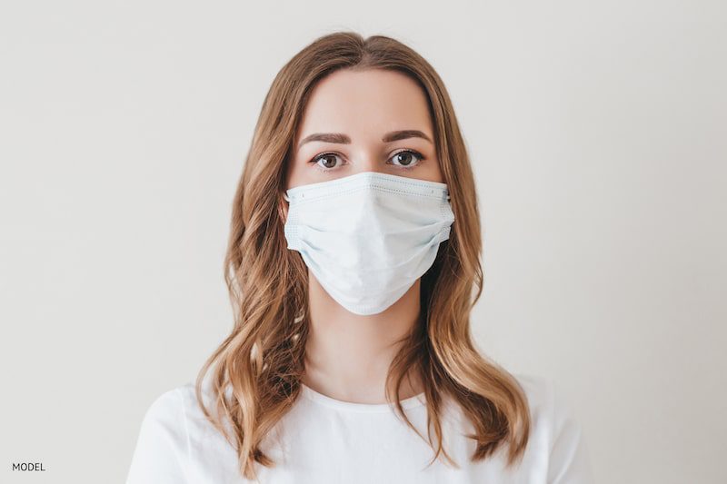 Young girl in a medical mask isolated on a white background.