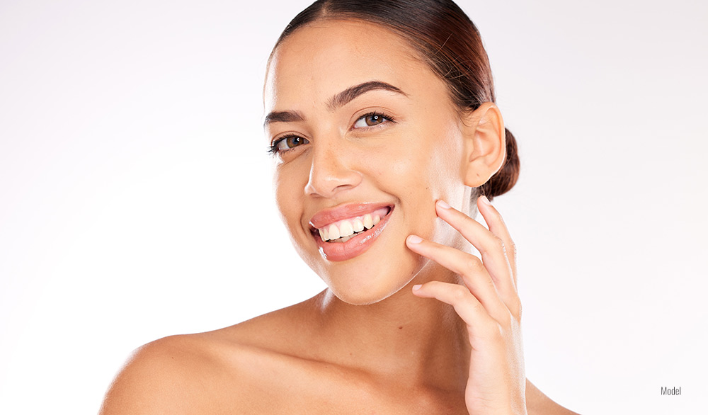 A pretty, smiling woman shows off her clear and radiant skin.