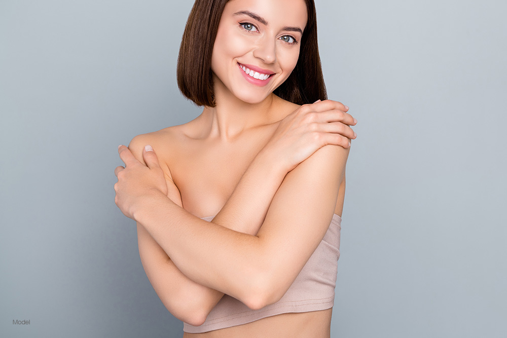 Woman covering her breast with her arms