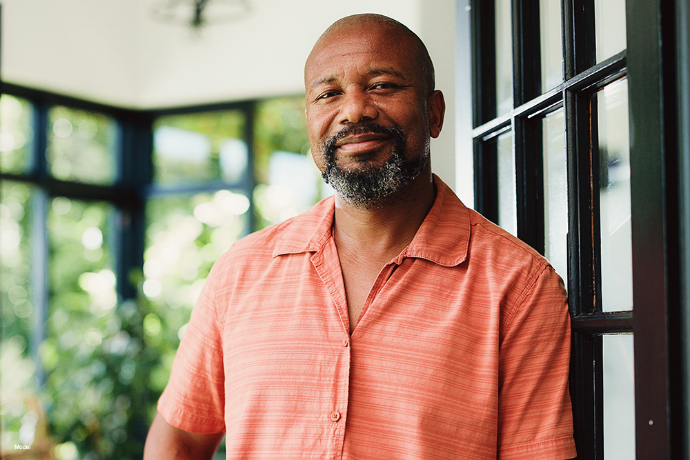 Mature bald man in a salmon colored shirt