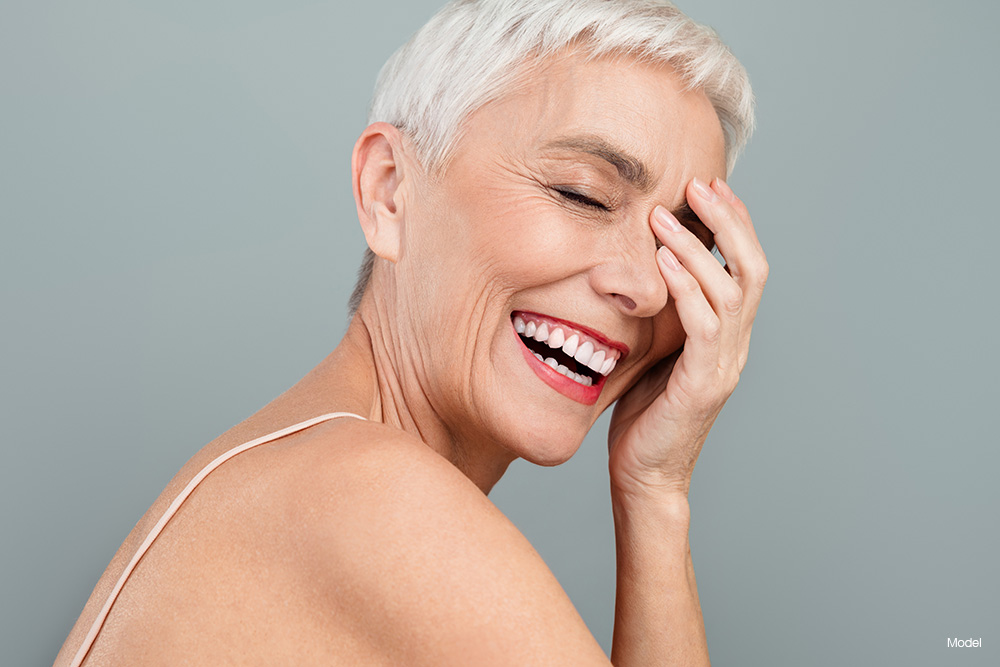 mature woman covering her eye, smiling